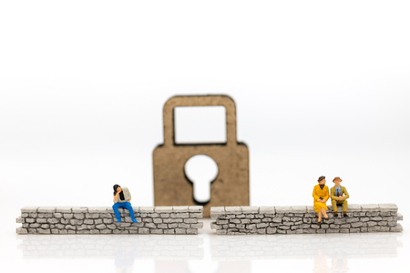 Miniature people: Businessman sitting on the wall and have master key is inside. Image use for business security center, protect conceptの写真素材