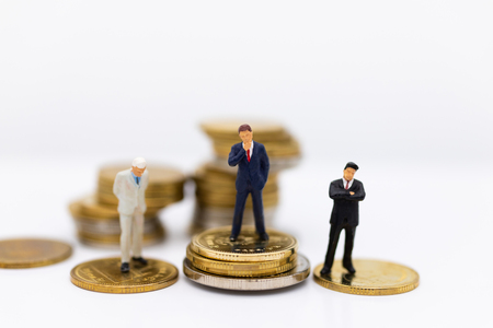 Miniature businessman and stack of coins. Image use for investment, saving money.の写真素材