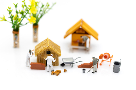 Miniature people: Construction workers building plans , have building materials, sand, brick, mortar. Use image for construction business.の写真素材