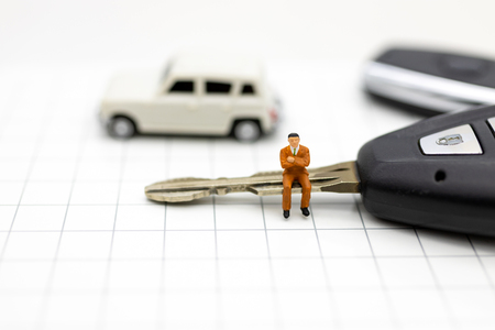Miniature people : Businessman sitting on car key. Image use for Advertising product in the market today, competition on the business trading.の写真素材