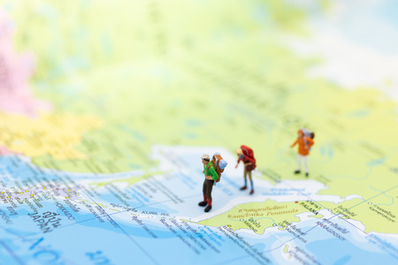Miniature people : traveler walking on the map Thai language. Used to travel to destinations on...