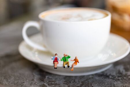 Miniature people: Businessman sitting with cup of coffee, image use for break time to charge energy during the dayの写真素材