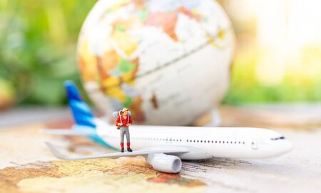 Miniature people: travelers with backpack standing on world map travel by plane. Image use for travel business concept.の写真素材