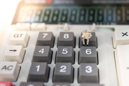Miniature people: Businessman stand on calculator, tax, profit margins of  background. Image use for...