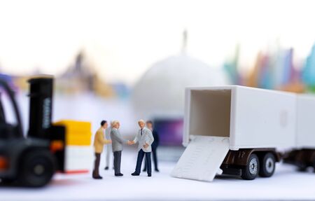 Miniature people : Businessmen shake hands to do business together. Image use for logistic concept,...