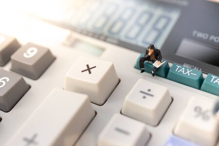 Miniature people: Businessman stand on calculator, tax, profit margins of  background. Image use for business concept.の写真素材