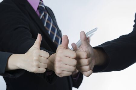 Successful teamwork concept: business people making thumbs up gesture.の写真素材