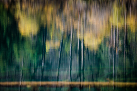 Reflection of autumn trees in waterの写真素材