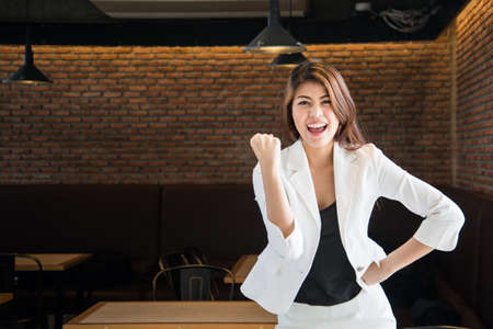 Happy excited business woman with her hand upの写真素材