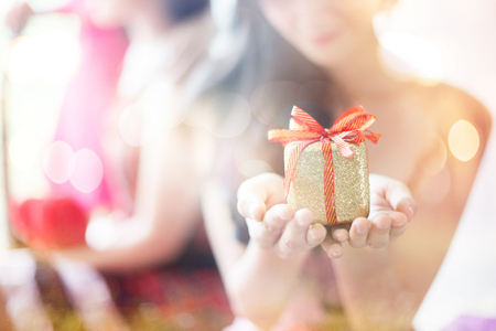 She was surprised and happy and holding a gift boxの写真素材