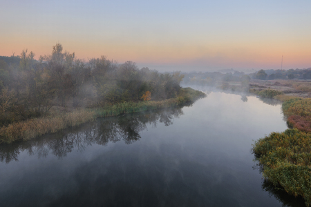 Cold morning landscape with a river. Grass covered by hoarfrostの写真素材