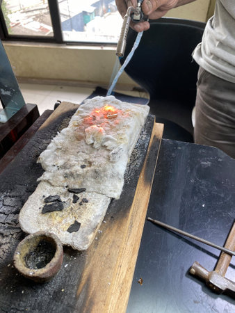 Jeweler melting metal with open flame blow torchの写真素材