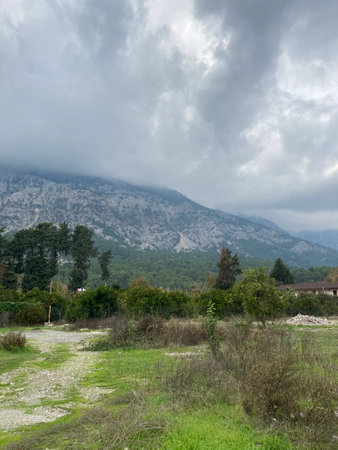 Low fluffy clouds hang over the high mountains, cover their peaksの写真素材