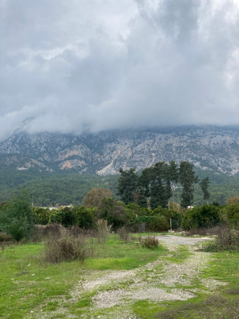 Low fluffy clouds hang over the high mountains, cover their peaksの写真素材
