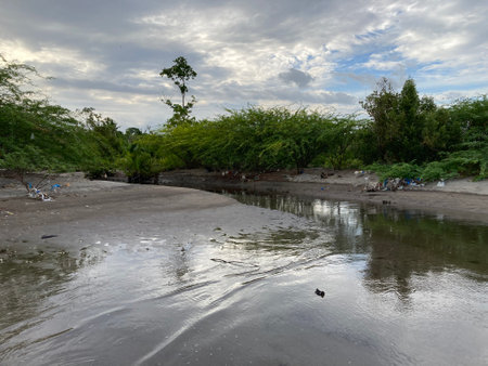 Philippines The river flowing down from the mountains flows into the sea on the shores of pollution with plastic and other garbage ecologyの写真素材
