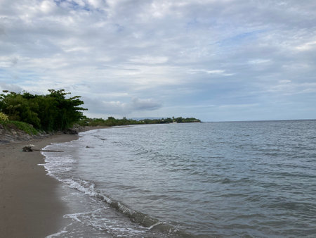 Small warm waves on the sandy shore of the sea gently stroke the shoreの写真素材