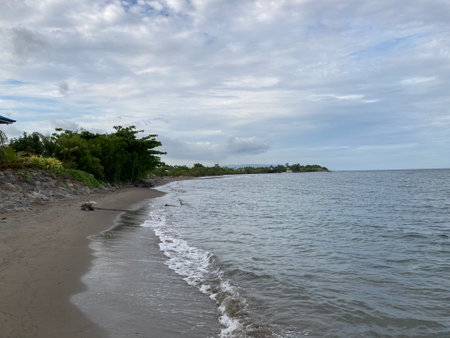 Small warm waves on the sandy shore of the sea gently stroke the shoreの写真素材