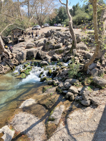 The stream of water flows through large stones and forms a small waterfallの写真素材