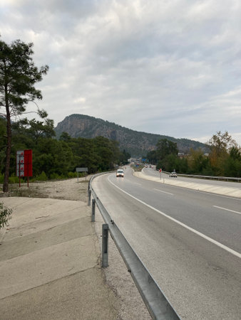 The highway runs along the mountains, cars move along itの写真素材