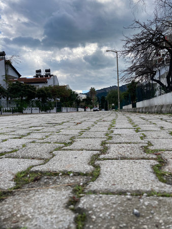 stone paving stones stretching into the distance along the houses against the background of low cloudsの写真素材