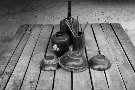 Tradintional chinese teapot, cups, bowl, jar and chopsticks in black and white photographの写真素材