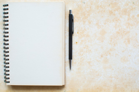 Notebook and pen on grunge cavasの写真素材