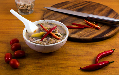 Traditional Thai Food with chillies tomatoes knife and blockの写真素材