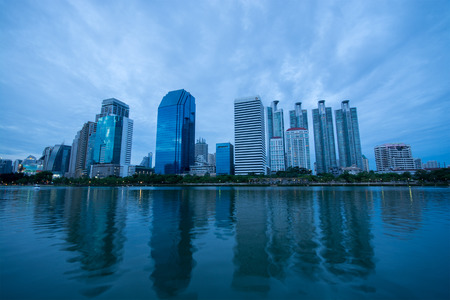 Bangkok, Thailand - July 5, 2015: Group of modern buildings near the lake at Benjakitti Park were under the rain clouds at twilight in Bangkok, Thailandのeditorial素材