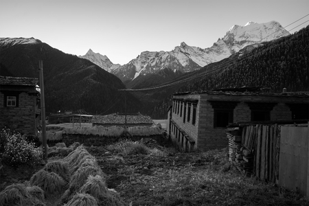 Sichuan, China - October 21, 2015: Farm at Yading Village, Sichuan, China under the rain clouds at twilight with mountain backgroundのeditorial素材