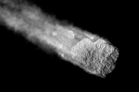 Comet moving in space. Asteroids and dust tail on black backgroundの写真素材