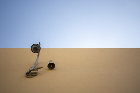 Electric lamp on concrete wall with blue sky