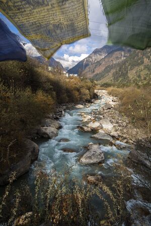 River flow pass valley in Himalaya with holy flag, indiaの写真素材