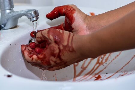 Assumption of murderer washing his hands that have a lot of blood in basinの写真素材