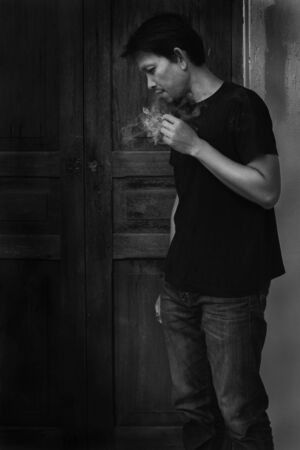 Man smoking cigarette, black and white photographyの写真素材
