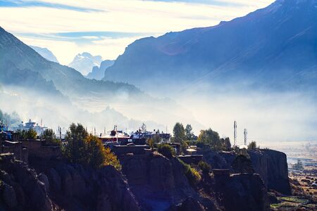 Local village on hill in the morning with smoke from kitchen, Pisang, Napalの写真素材