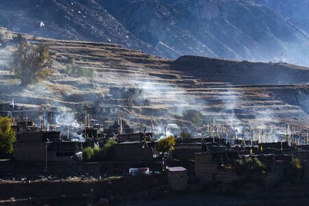 Local village on hill in the morning with smoke from kitchen, Pisang, Napalの写真素材