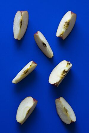 Pieces of apple on blue background, fruit backgroundの写真素材