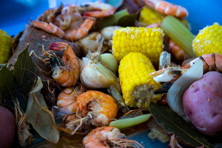 Boiled shrimp and vegatables on tray with spice bagの写真素材
