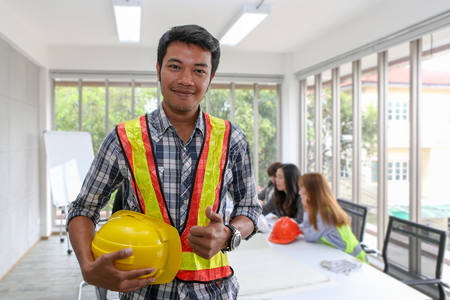 Portrait of Asian male contractor engineer in meeting room. at the office. Electricians carpenter or technical operaters and labourers or moving operators. The engineer holds the thumb that translates as excellent.の写真素材