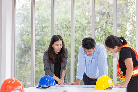 Three engineers working meeting room at the office. Three workers are talking construction plan. Electricians carpenter or Technical operaters and Labourers or Moving Operators. Asian people.の写真素材
