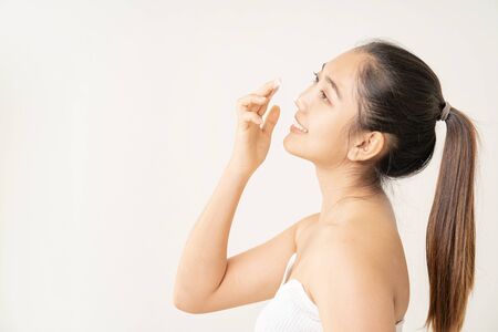 Young woman experimenting with skin care creams.の写真素材