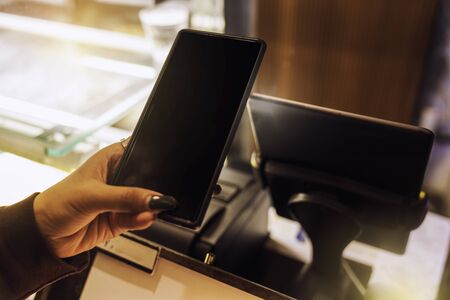 Contactless payment. Customer woman using Mobile phone scanning for payment. Woman paying with...