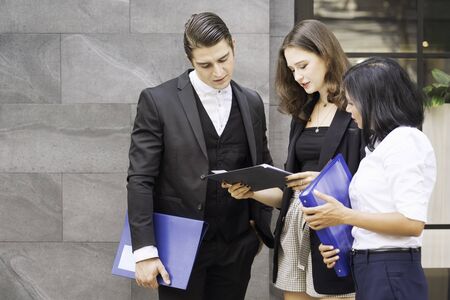Co working space concept. Asian business looking and thinking in front of folder while stand at...