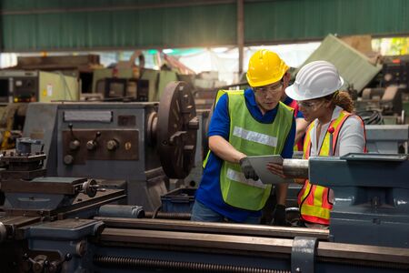 Factory engineers and chief technicians are watching the operation of the machinery through the...