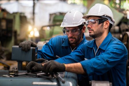 Engineers and skilled technicians are maintaining machinery. Professional technicians are working in industrial plants.の写真素材