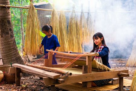 Asian girls is weaving the mat.の写真素材