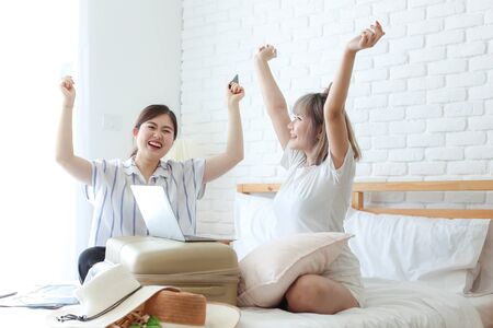 Tourism concepts. Two young women are happy with the success of their booking. Two girl rejoicing while holding passport and travel tickets.の写真素材