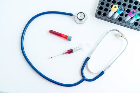 Syringe, medical stethoscope and blood tubes on table.の写真素材