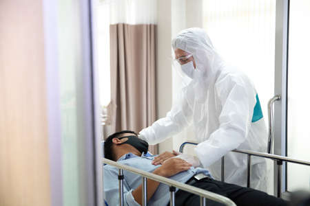Doctors and nurses is examining the patients in the hospital. Doctors and staff to prevent COVID 19 Checking and treating patients in a controlled area, state quarantine.の写真素材