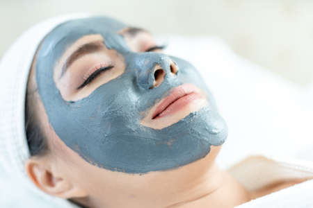 Beautiful woman masking skin in a facial spa shop